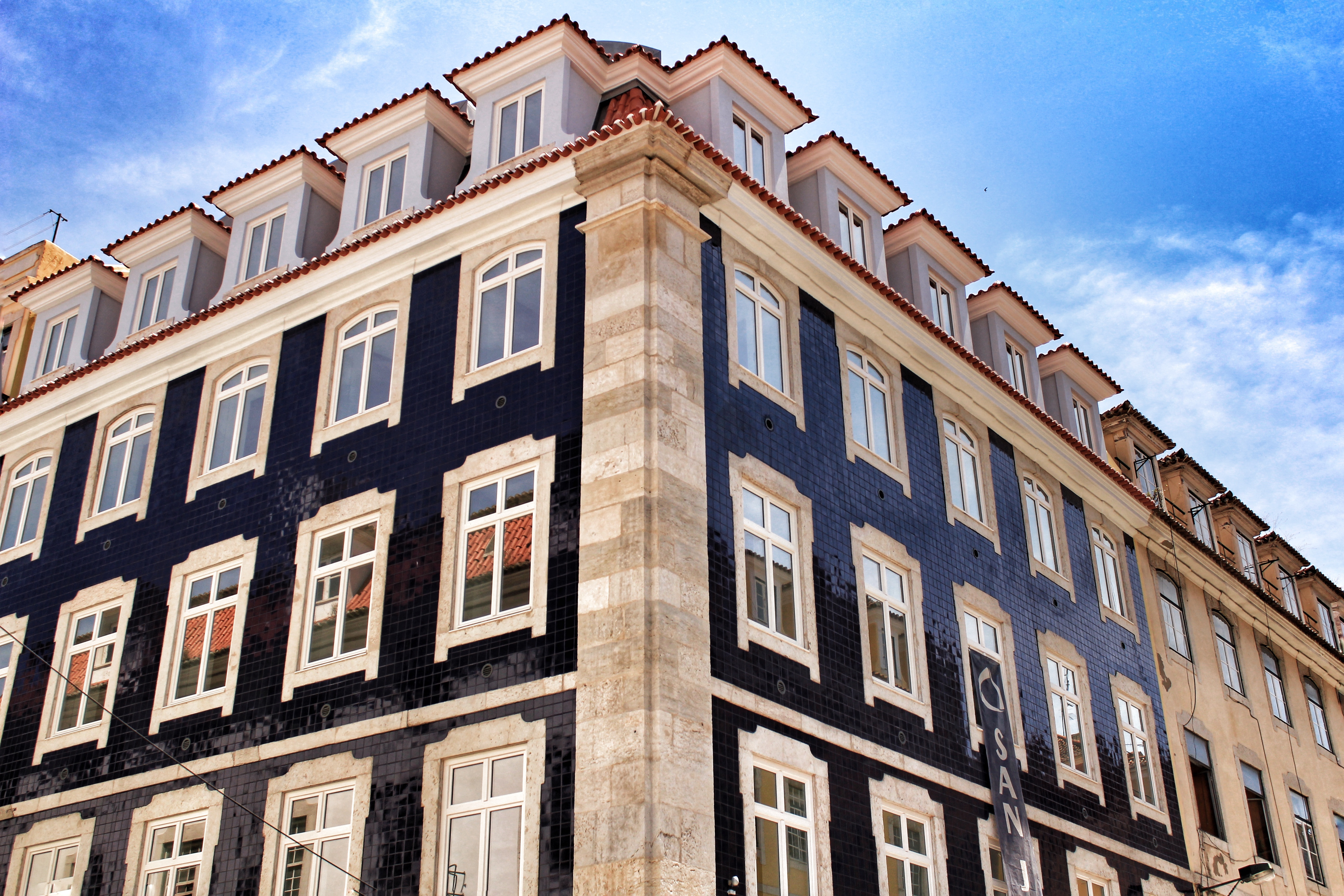 Old colorful and majestic tiled facades with vintage streetlight in Lisbon streets in Spring.
